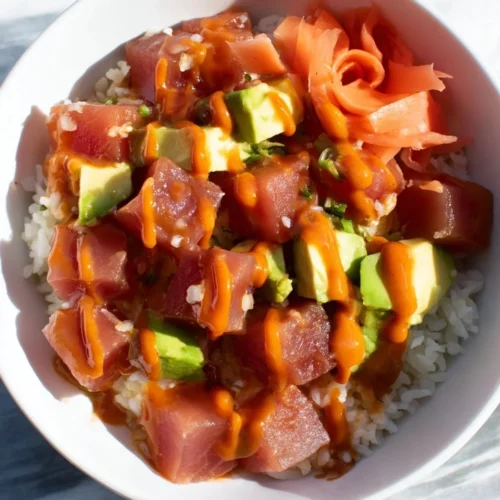 A vibrant spicy tuna poke bowl topped with fresh ingredients and a hint of spice.